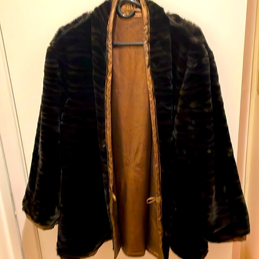 This coat is black Faux with a lining of a copper colored reversible.
